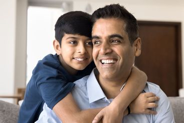Dad and son hugging, showing strong bond, feeling...