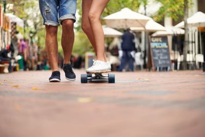 People, skateboarding and outdoor in city, legs and...