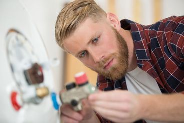 male plumber working on central heating boiler