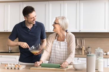 Young man loving son help mother to cook handmade bakery