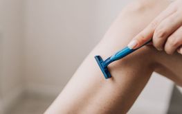 shaving legs with a blue razor
