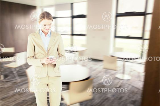 Composite image of businesswoman using her mobile phone