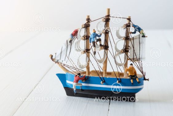 miniature climbers climbing on sailboat model