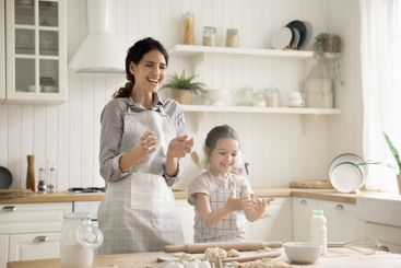 Laughing mum little daughter rolling dough clapping...
