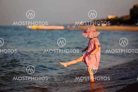 the girl creates splashes a foot at the sea