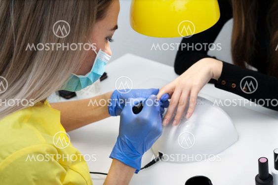 Nail care. Manicure in the salon. The master manicures...