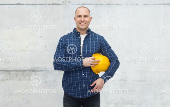 smiling man with helmet over concrete wall