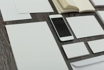 Blank sheets, notebook, and a smartphone arranged on a...