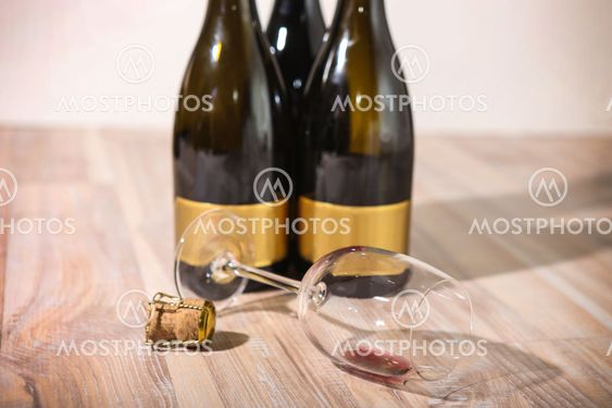 bottles with wine and empty wine glass