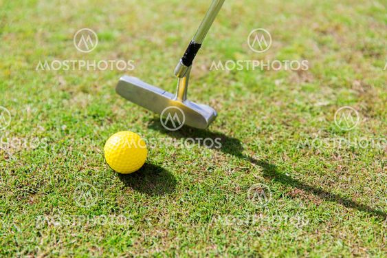 close up of club and ball near hole on golf field