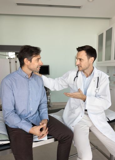 Positive male doctor explaining diagnosis to friend patient