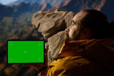Happy adventurer standing at the rocky top next to copy...