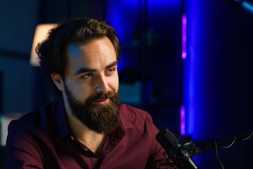 Close up of content creator using mic in studio to do...