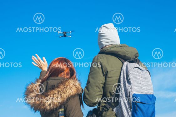 Two couple taking a selfie with a drone, drone navigating