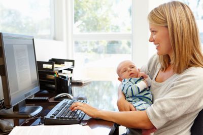 Mother working in home office with baby