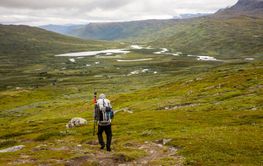 Man with backpack hiking on hill