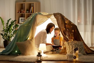 family with tablet pc in kids tent at home