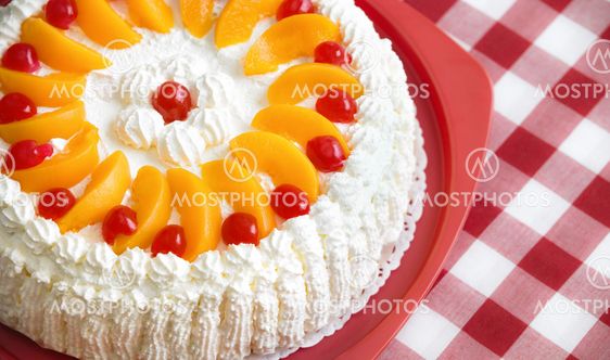 Homemade cream cake with peaches and cherries