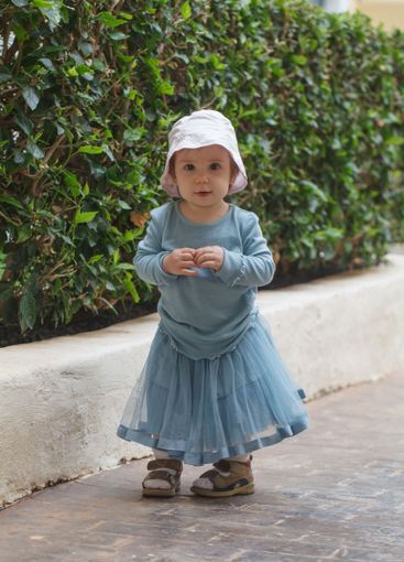 Adorable baby girl 1 year old playing in the yard outdoors