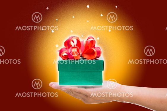 Green gift box with red bow on yellow and brown background