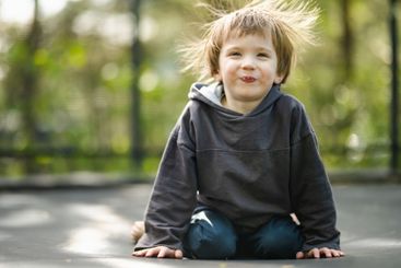 Little boy jumping on a trampoline in a backyard on warm...