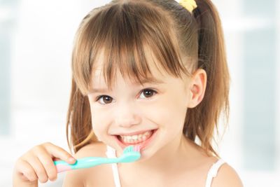 happy little girl brushing her teeth