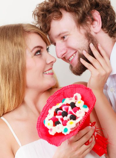 Loving couple with candy bunch flowers. Love.