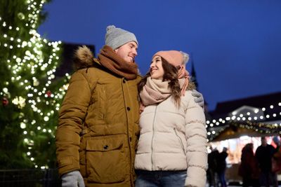 happy couple talking at christmas tree