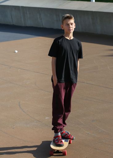 Handsome teenager standing with skateboard. Adolescent...