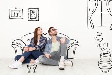 Millennial couple imagining interior of their new home,...
