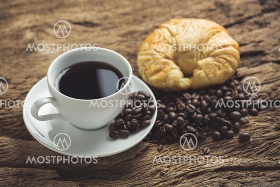 white coffee cup and roasted coffee beans around