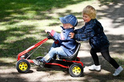 Två barn leker med trampbil 1