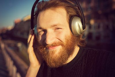 young stylish bearded man listening to music