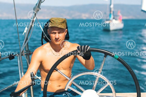Men skipper on the yacht during the sail races in the sea. Sailing, extreme sports, luxury leisure and healthy lifestyle.