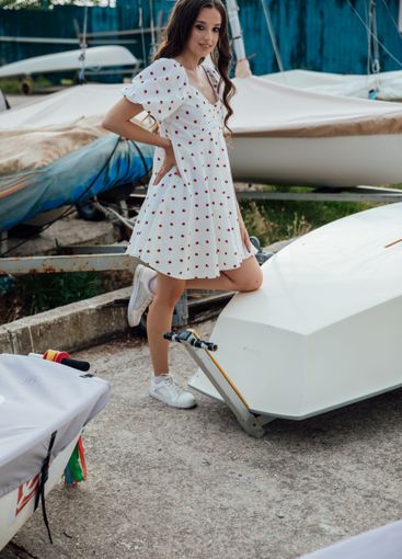 Beautiful brunette woman in summer dress by the boat in...