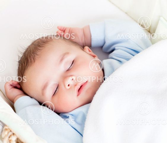 Portrait of a peaceful baby sleeping in his cradle at home