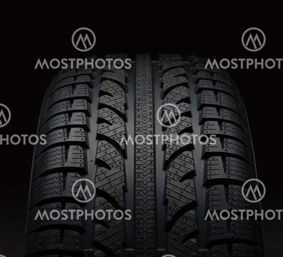 Close-up of car tire over black background