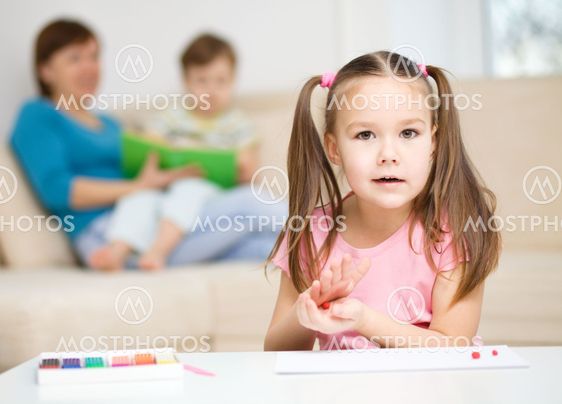 Little girl is playing with plasticine