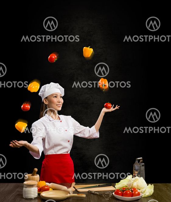Asian woman chef juggling with vegetables