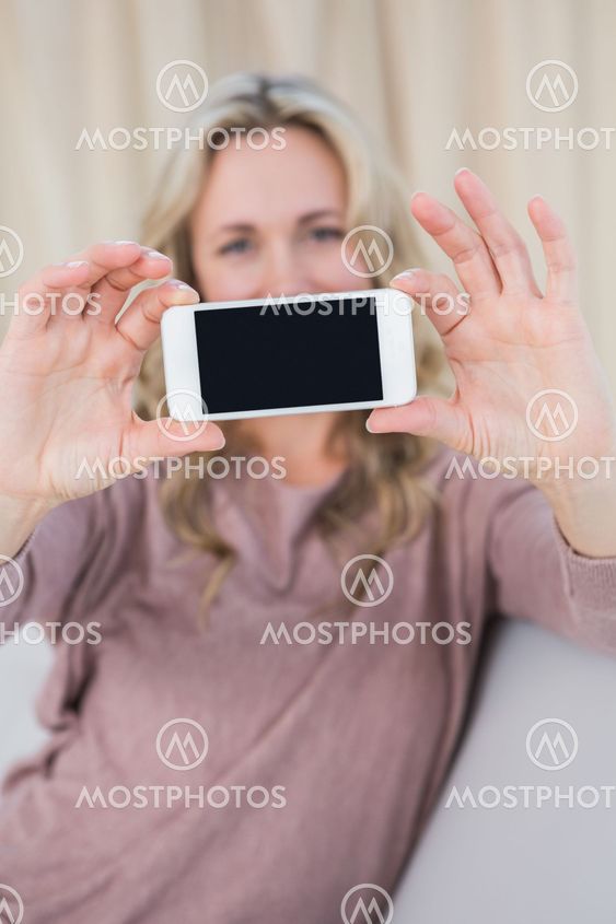 Pretty blonde showing screen of smartphone