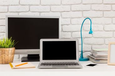 Modern home office setup featuring a laptop, monitor,...