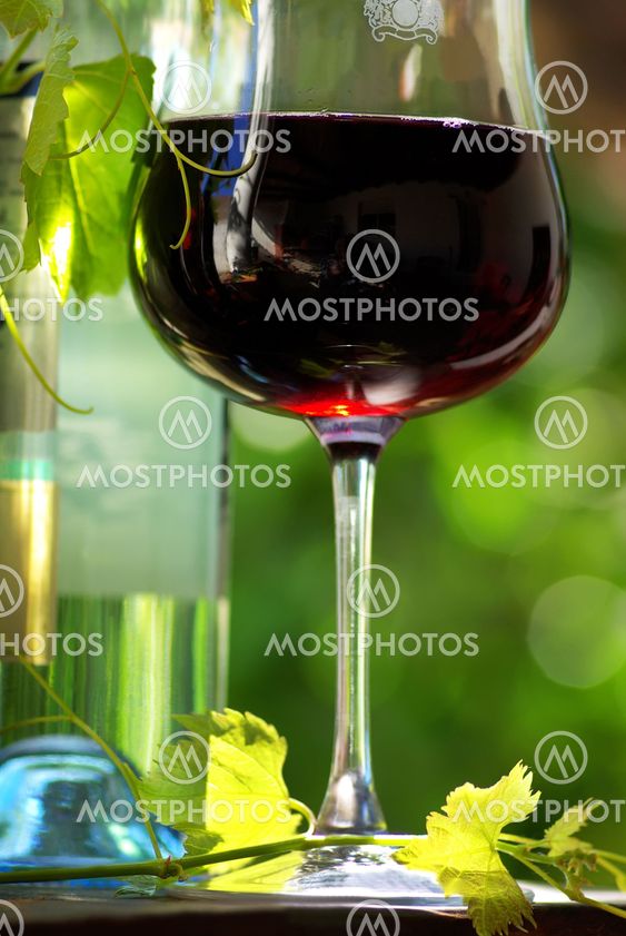 Bottle of red wine with glass.