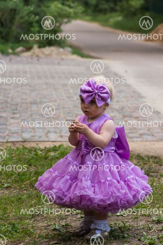 Beautiful little girl standing on the street in the model...
