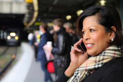 Kvinna med mobil på perrong 3