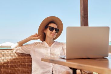 Young woman using laptop computer on a beach
