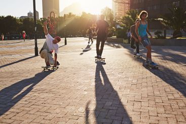 People, skating and skateboard for fitness in city with...