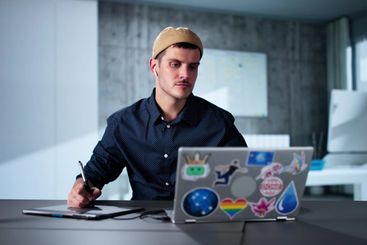Happy Young Male Designer Using Laptop