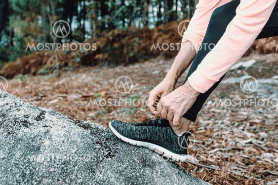 Close up of an old woman tying her tennis laces in the...