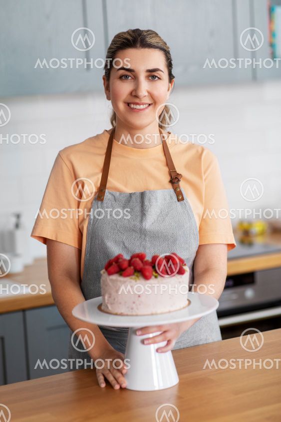 happy woman with raspberry cake on kitchen at home