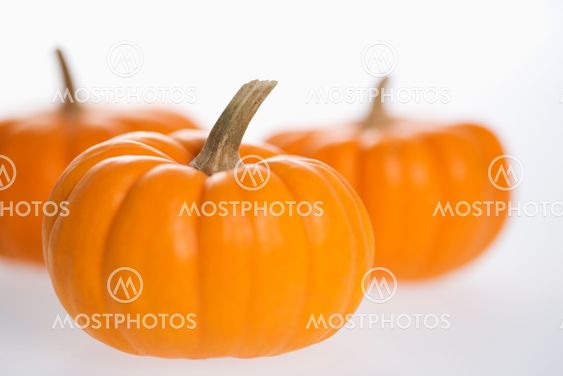 Three pumpkins on white.